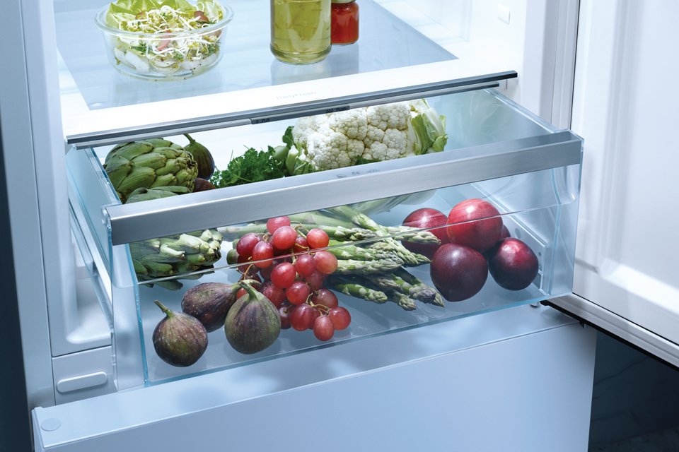 Inside of a Miele refrigerator, with bottom drawer containing fruits and veggies.